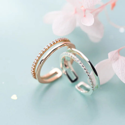 Detailansicht der offenen Ringe in Silber und Roségold mit glitzerndem Zirkonia-Besatz und zarter zweireihiger Optik.