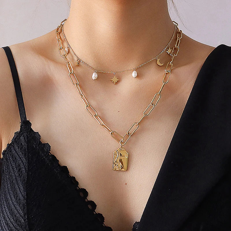 Kombination aus goldener Mond-Stern-Halskette und Perlen-Kette im Lagenlook getragen