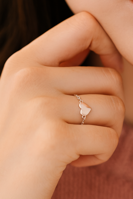 Filigraner Kettenring in 9252er Silber, getragen am Finger, verstellbar, mit einem einem Herz-Charm.