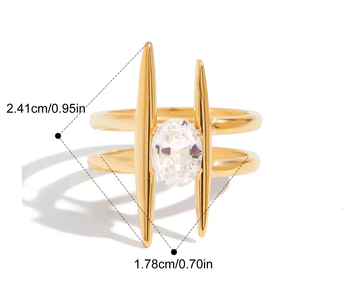 Grafische Darstellung eines goldenen Rings mit 18K PVD-Vergoldung. Er hat ein lineares, sich kreuzendes Design und ist mit einem großen, klaren Zirkonia Stein besetzt. Die Maße sind ebenfalls angegeben mit einem Innendurchmesser von 1,8 cm und einer Breite von 2,4 cm.