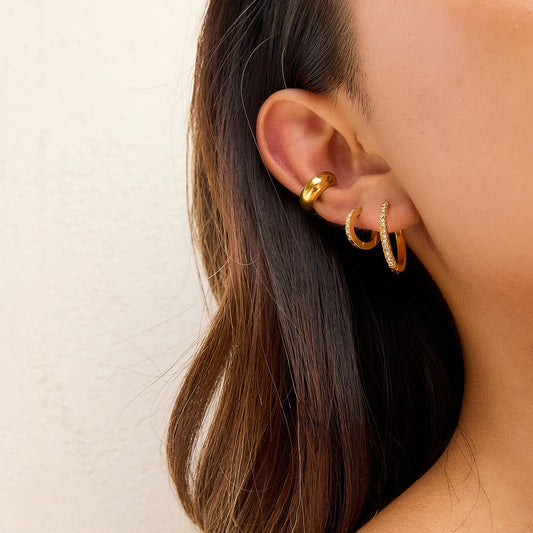 Kleine goldene Creolen getragen an Ohr einer Frau | PVD 18K vergoldete Edelstahl-Ohrringe | minimalistischer Ohrschmuck