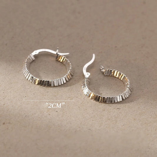 Zwei strukturierte Kreolen-Ohrringe (925er Silber) liegen nebeneinander, mit einem sichtbaren Maßband zur Größenbestimmung.