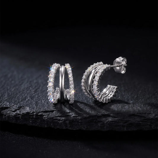 Dreireihige Zirkonia-Creolen aus 925 Sterling Silber im Huggie-Look mit Schmetterlingsverschluss auf schwarzem Steinuntergrund