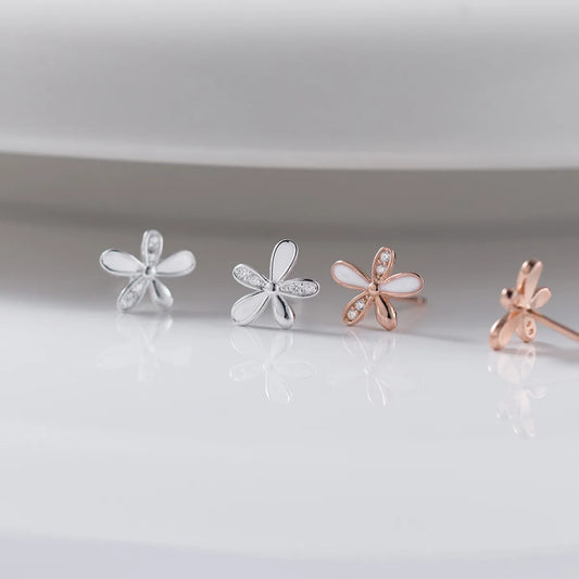 Nahaufnahme von zwei edlen Ohrringen aus 18K vergoldetem Silber mit glänzendem Herz-Element, funkelnden Zirkonia-Steinen und hängenden Fransen-Gliederketten.