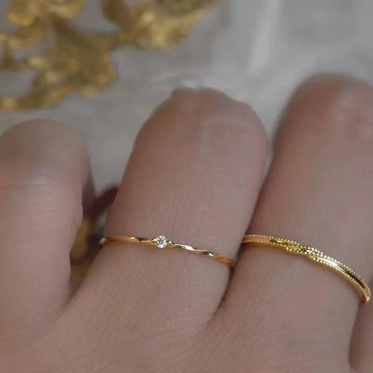 Zwei 18K Gold Platin vergoldete 925 Silber Ringe mit einzelnen Zirkonia-Steinen, übereinander am Finger getragen (Stapellook).