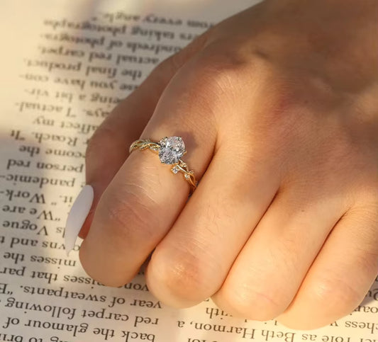 „Nahaufnahme einer Hand, die den goldvergoldeten Rankenring beim Lesen eines Buches trägt – eleganter und zeitloser Stil.“