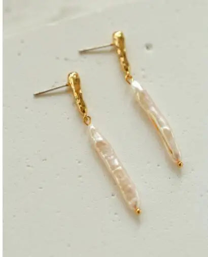 Lange Ohrhänger aus schmalen Barockperlen mit einer edlen 18K Gold-Fassung für einen zeitlosen, natürlichen Look.