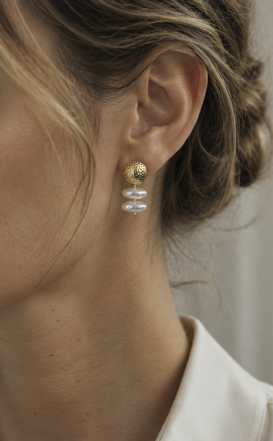 Seitliche Nahaufnahme eines Models, das einen der goldenen Baroque-Perlen-Ohrringe trägt, zeigt die elegante, unregelmäßige Form der Perlen.