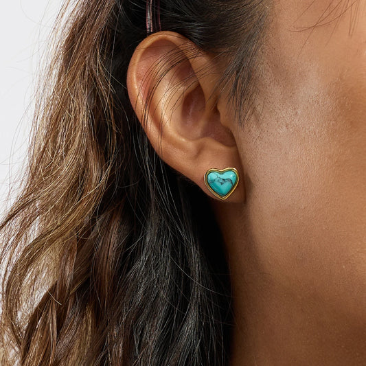 Nahaufnahme am Ohr (von unten):
Nahaufnahme eines Herz-Ohrsteckers aus 18K vergoldetem Edelstahl am Ohr einer Frau, aus einer unteren Perspektive.