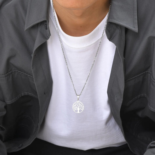 Silberfarbene Edelstahlkette mit Lebensbaum-Medaillon, getragen von einem Mann über einem weißen T-Shirt und offenem, dunklem Hemd, mittlere Ansicht.