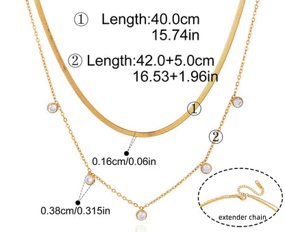 Technisches Produktfoto des geschichteten goldvergoldeten Edelstahl-Kettensets mit Maßen; die feine Kette ist 40 cm lang (15,74 Zoll), die Paperclip-Kette ist 42 cm lang (16,53 Zoll) plus 5 cm (1,96 Zoll) Verlängerung, und die Zirkonia-Steine haben einen Durchmesser von 0,38 cm (0,32 Zoll).