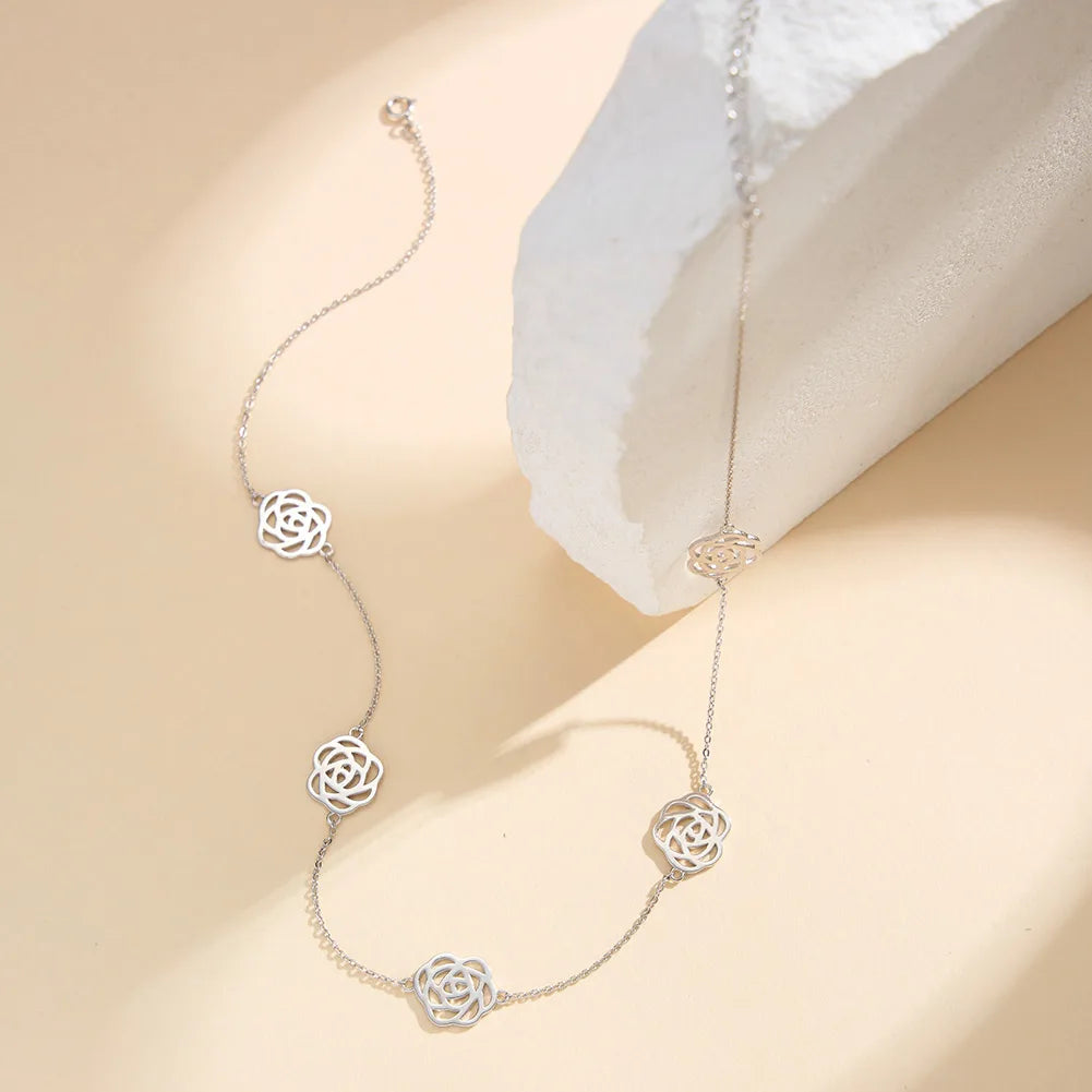 Detaillierte Nahaufnahme der filigranen Gliederkette aus 925er Sterling Silber und der kunstvoll gestalteten, offenen Rosenblüten-Elemente im reinen Silber-Finish.