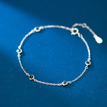 Schlichte Produktansicht des 925er Silber-Armbands mit schwarzen Zirkonia-Steinen auf blauem Untergrund.