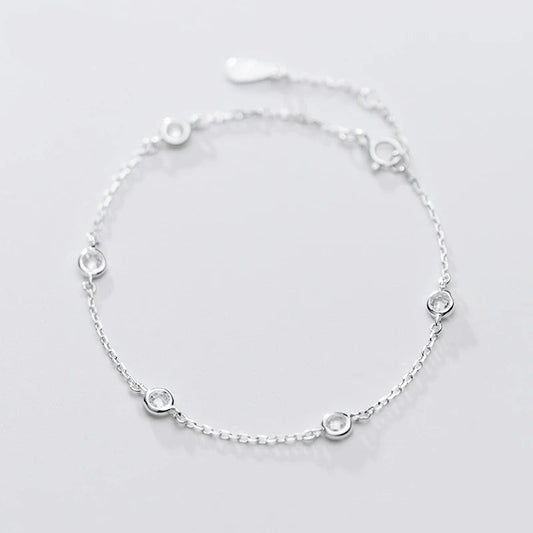 Nahaufnahme eines filigranen Armbands aus 925er Sterling Silber mit gefassten, klaren Zirkonia-Steinen auf weißem Hintergrund.