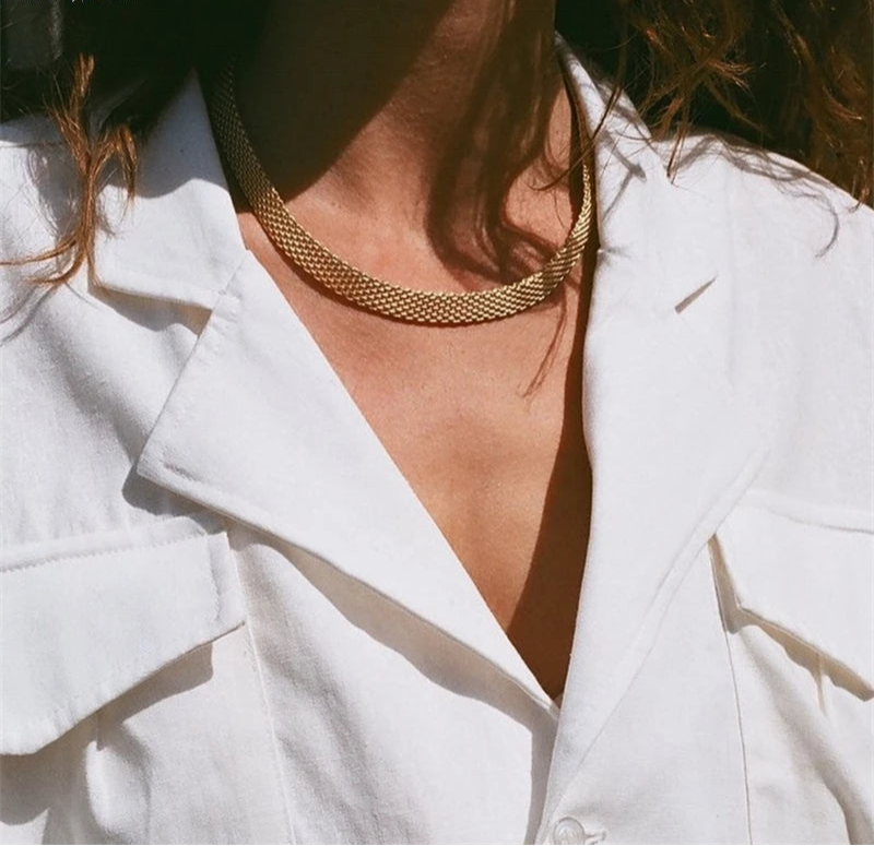 Kurze, goldene Schlangenkette aus Titan getragen zu weißer Bluse | dezenter Halsschmuck für Damen | zarte Kette