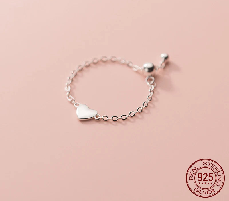 Größenverstellbarer Kettenring aus 925er Sterlingsilber mit kleinem Herz-Anhänger.