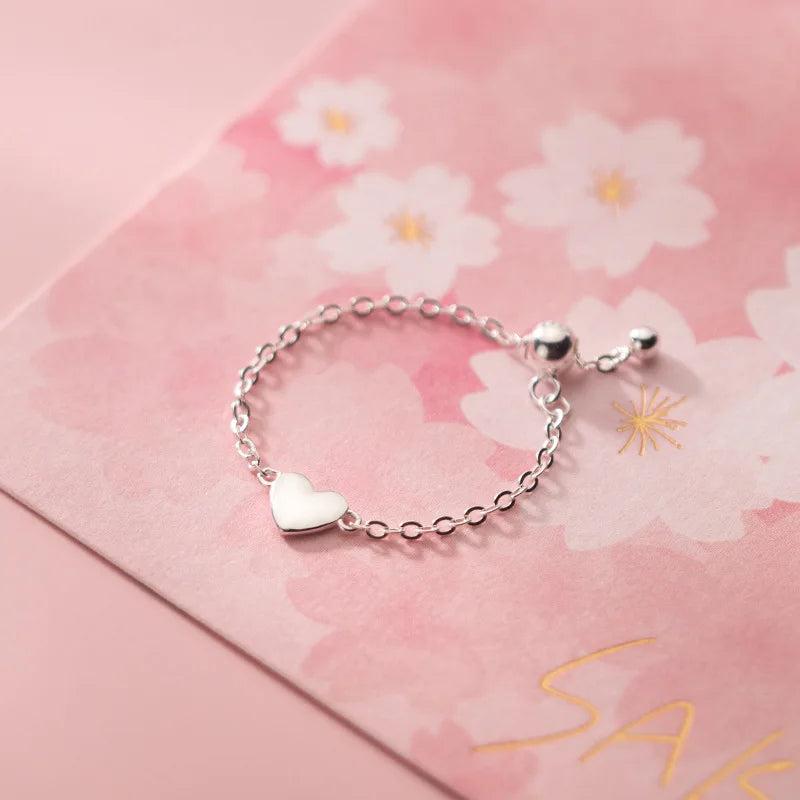 Filigraner Kettenring in Silber, verstellbar, mit einem Schiebeverschluss in Kugelform und einem Herz-Charm.