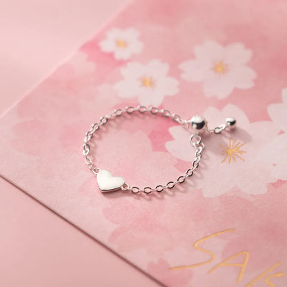 Filigraner Kettenring in Silber, verstellbar, mit einem Schiebeverschluss in Kugelform und einem Herz-Charm.