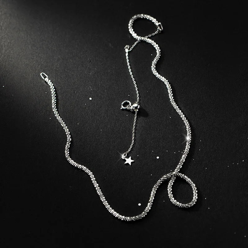 „Nahaufnahme der feinen Kugelkette aus Sterlingsilber auf dunklem Hintergrund, die die Struktur der Kette und den Sternen-Anhänger zeigt.“