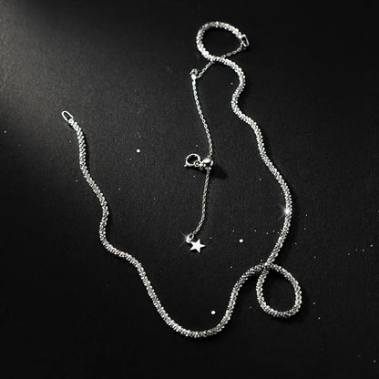 „Nahaufnahme der feinen Kugelkette aus Sterlingsilber auf dunklem Hintergrund, die die Struktur der Kette und den Sternen-Anhänger zeigt.“