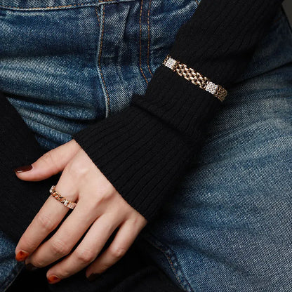 Seitliche Trageansicht des breiten Messing-Armbands mit 18K Vergoldung und Zirkonia-Akzent über einem schwarzen Ärmel.