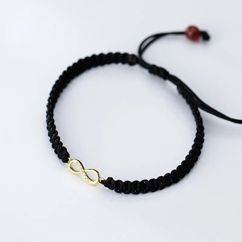 Schwarze Ausführung des geflochtenen Textilarmbands mit vergoldetem Infinity-Symbol aus 925er Silber.