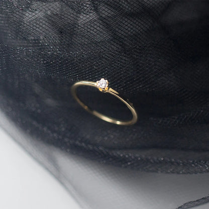 Nahaufnahme des vergoldeten Solitär-Rings mit Zirkonia-Stein auf edlem, schwarzem Hintergrund