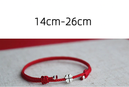 Produktansicht des verstellbaren roten Kordelarmbands mit Silber-Kleeblatt (Länge 14 cm bis 26 cm).