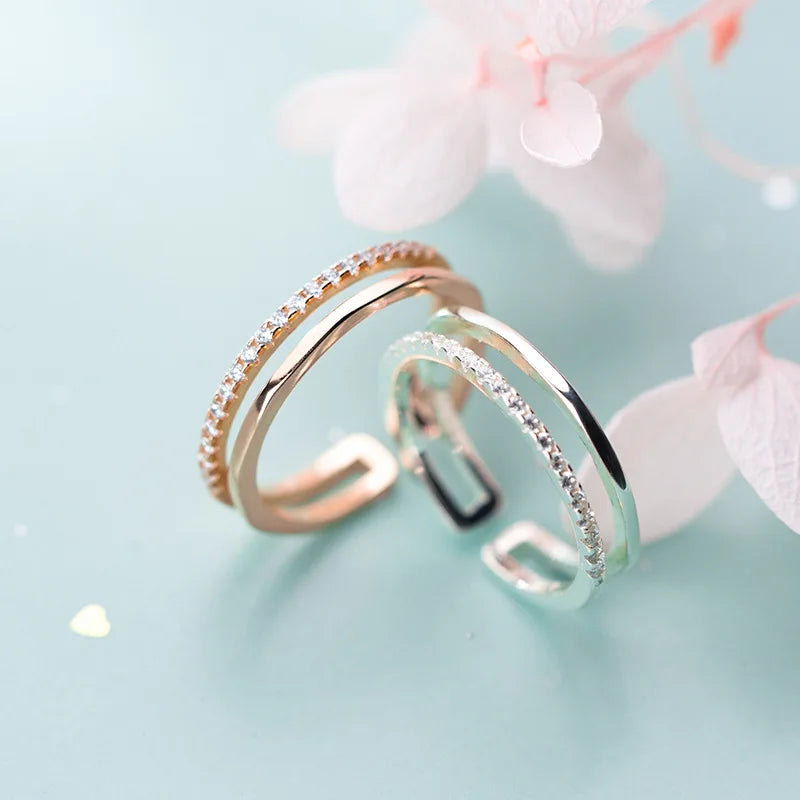 Detailansicht der offenen Ringe in Silber und Roségold mit glitzerndem Zirkonia-Besatz und zarter zweireihiger Optik.