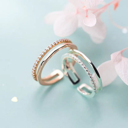 Detailansicht der offenen Ringe in Silber und Roségold mit glitzerndem Zirkonia-Besatz und zarter zweireihiger Optik.