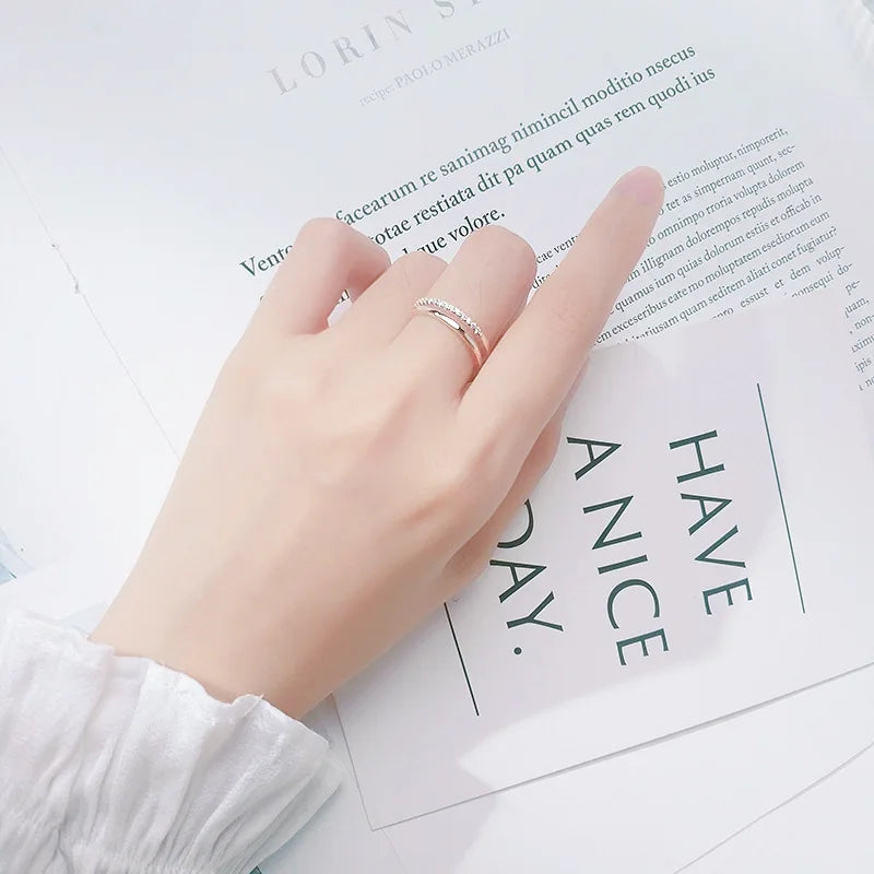 Elegante Trageansicht: Der verstellbare doppelreihige Zirkonia-Ring am Zeigefinger kombiniert mit hellem Lifestyle-Hintergrund.