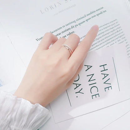 Elegante Trageansicht: Der verstellbare doppelreihige Zirkonia-Ring am Zeigefinger kombiniert mit hellem Lifestyle-Hintergrund.