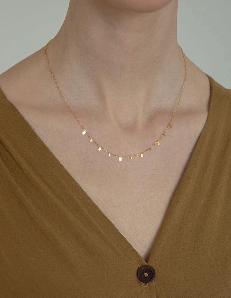Zarte Halskette aus 18K vergoldetem Titan mit Plättchen | kurze goldene Kette mit quadratischen Anhängern getragen
