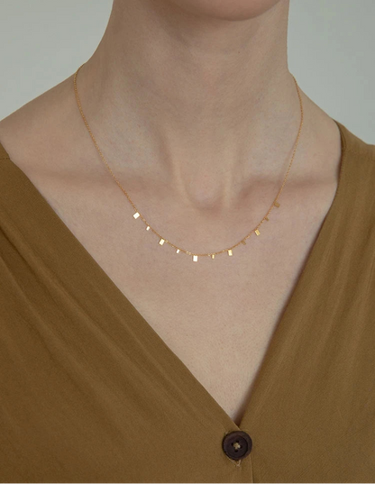 Zarte Halskette aus 18K vergoldetem Titan mit Plättchen | kurze goldene Kette mit quadratischen Anhängern getragen