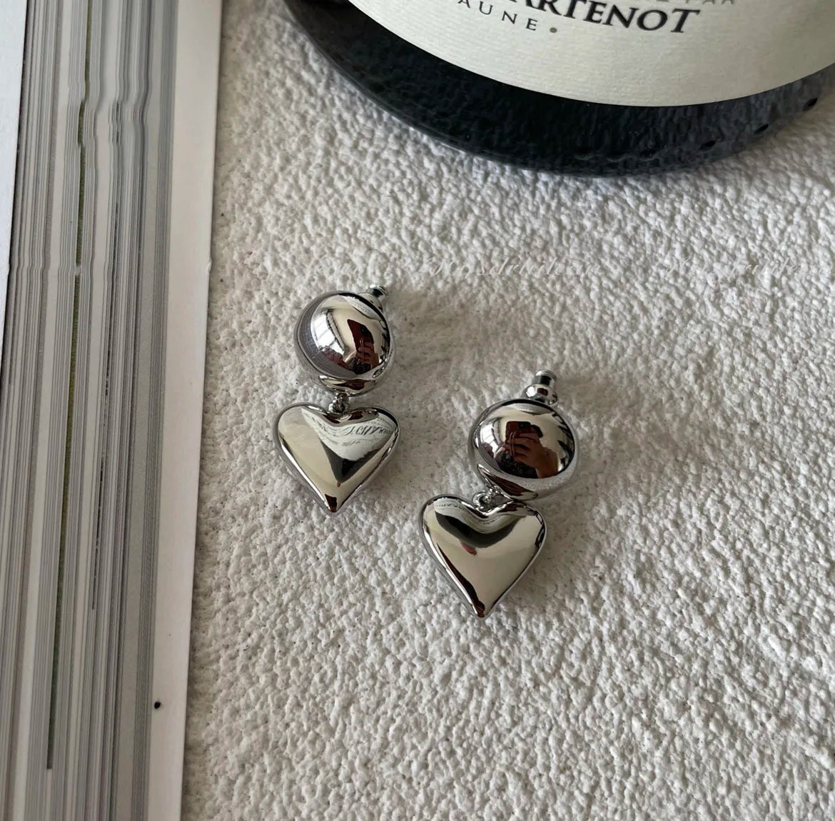 Silberfarbene minimalistische Ohrringe mit Kugeloberteil und hängendem puffigen Herz