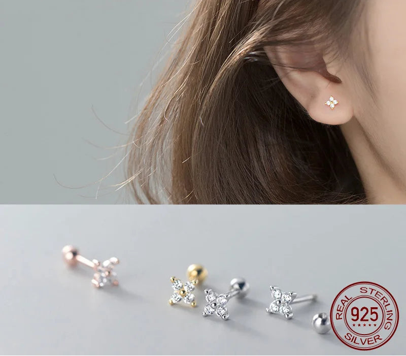 Nahaufnahme vom Ohr einer Frau mit einem filigranen, blütenförmigen Ohrstecker aus 925er Silber mit funkelnden Zirkonia-Steinen.
