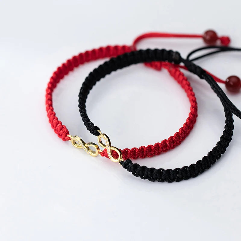 Partner-Set des verstellbaren Kordelarmbands mit vergoldetem Unendlichkeitszeichen in Rot und Schwarz.