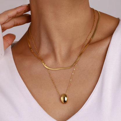 Doppellagige Halskette aus PVD 18K vergoldetem Edelstahl mit Snake Chain und Ovalanhänger getragen | Damen-Layering-Kette