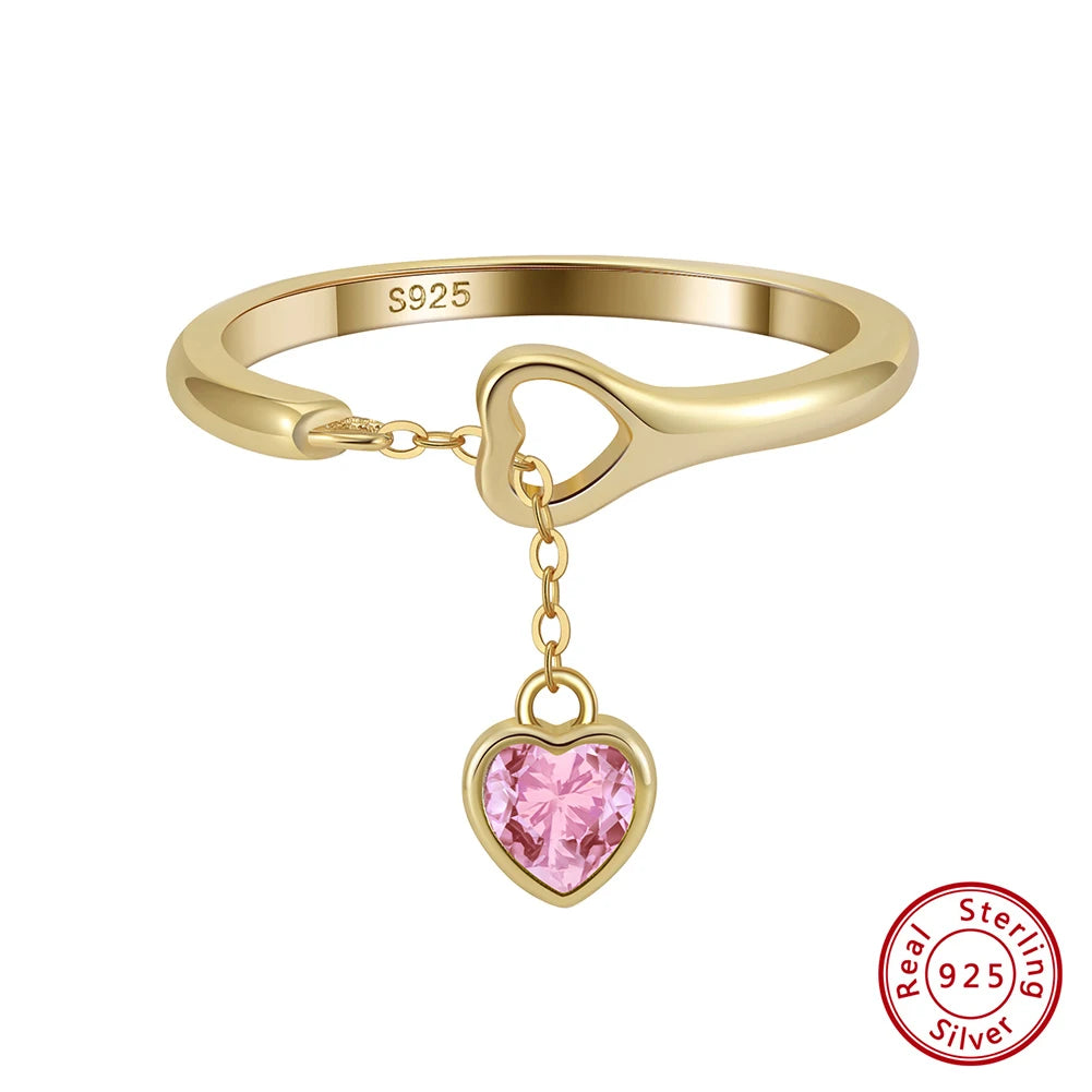 Freigestellter 18K Goldring mit hängendem rosa Herzanhänger aus Zirkonia.
