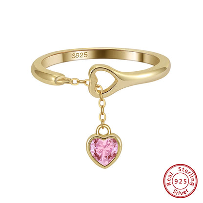 Freigestellter 18K Goldring mit hängendem rosa Herzanhänger aus Zirkonia.