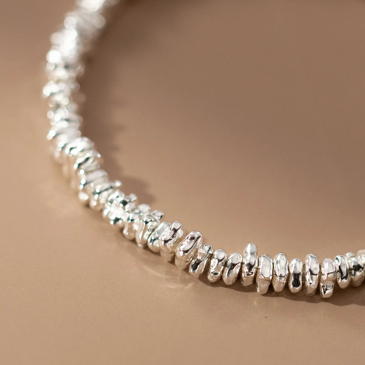 Nahaufnahme des Armbands mit den unregelmäßigen 925er Silber-Elementen, die die strukturierte Oberfläche der einzelnen Glieder hervorhebt.
