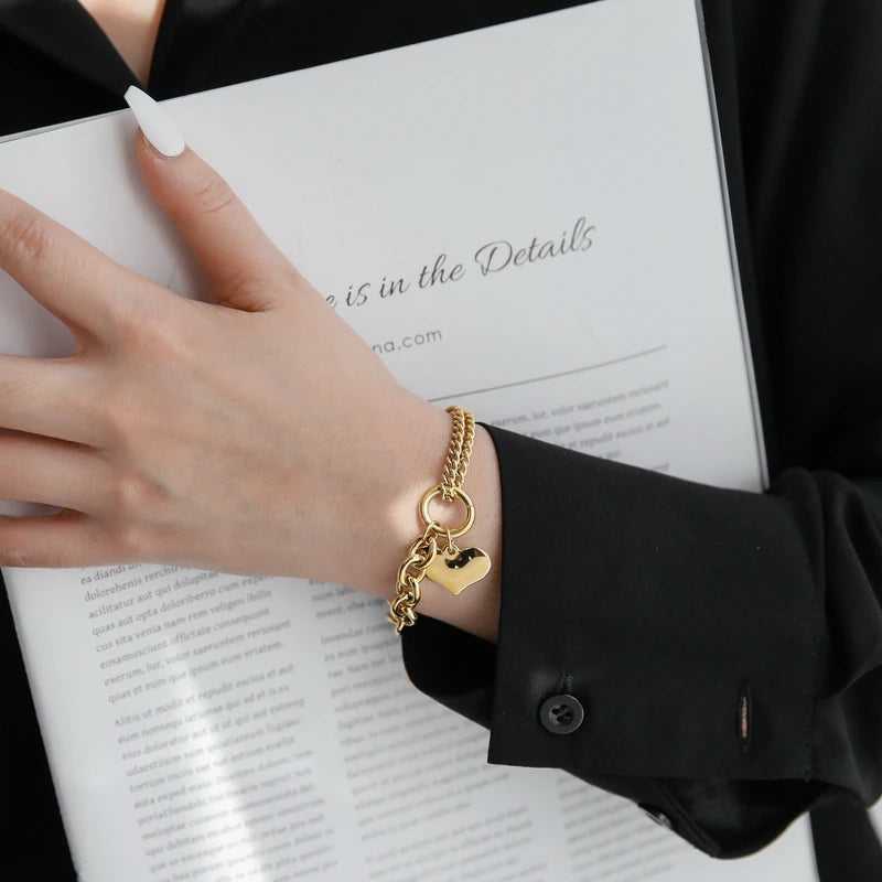 Stylischer Armschmuck im Chunky-Chain-Look: Vergoldetes Herz-Armband kombiniert mit elegantem Outfit