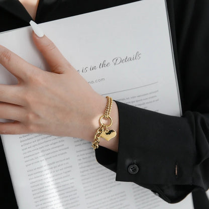 Stylischer Armschmuck im Chunky-Chain-Look: Vergoldetes Herz-Armband kombiniert mit elegantem Outfit