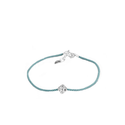  Armband mit mintgrünem Textilband, das einen kleinen runden Anhänger aus 925er Silber mit einem zentralen Zirkoniastein und einen Verschluss mit einem kleinen Herz-Detail zeigt.