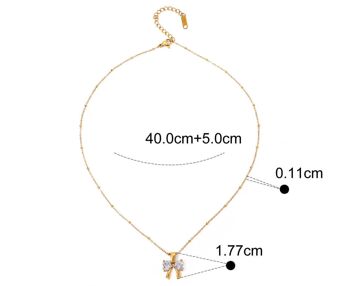 Produktmaße der goldenen Schleifenkette: 40,0 cm Länge plus 5,0 cm Verlängerung, 0,11 cm Kettenbreite und 1,77 cm Anhängergröße