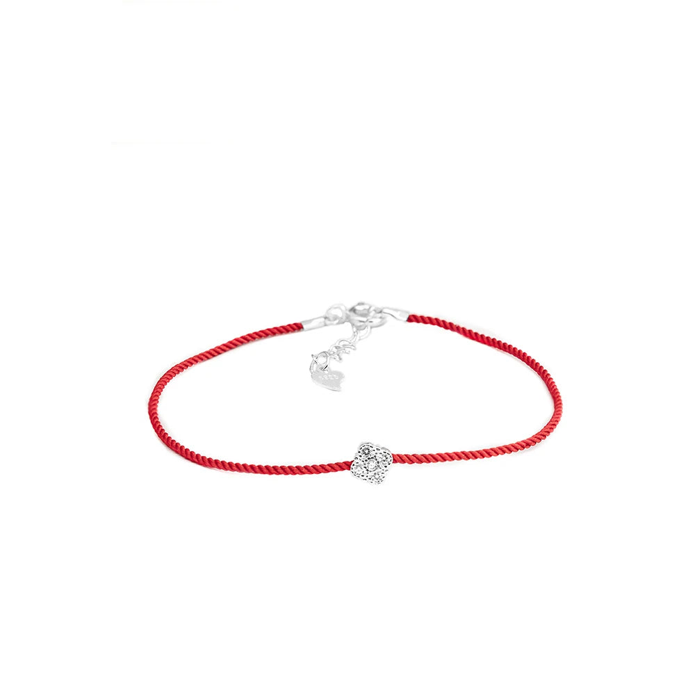 Armband mit leuchtend rotem Textilband und einem kleinen, runden Anhänger aus 925er Silber mit einem zentralen Zirkoniastein. Das Armband hat einen verstellbaren 925er Silber-Verschluss mit einem kleinen Herz-Anhänger.