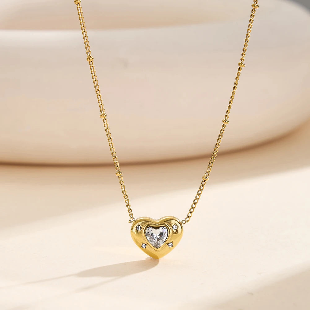 Nahaufnahme der goldenen Edelstahl-Kette mit 18K Vergoldung und Herzanhänger auf hellem Untergrund.