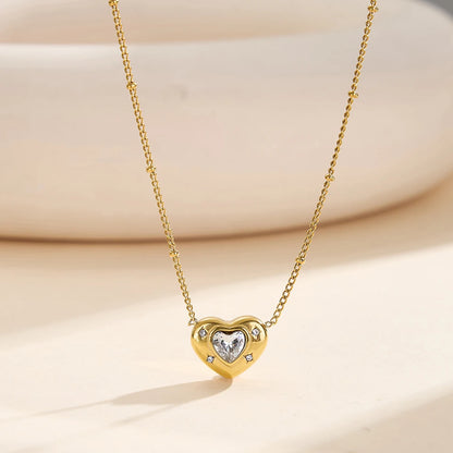 Nahaufnahme der goldenen Edelstahl-Kette mit 18K Vergoldung und Herzanhänger auf hellem Untergrund.