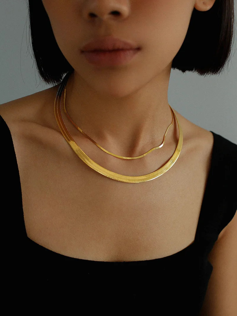 Nahaufnahme einer goldenen Schlangenkette mit Glanzeffekt | goldene Kette flach | vergoldeter Schmuck für Frauen