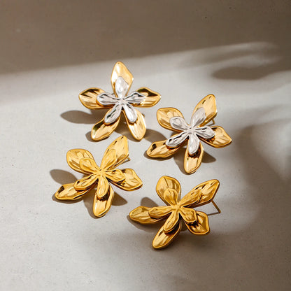 Paar goldene Blumen-Ohrringe, PVD 18K vergoldeter Edelstahl, auf hellem Hintergrund | floraler Schmuck
